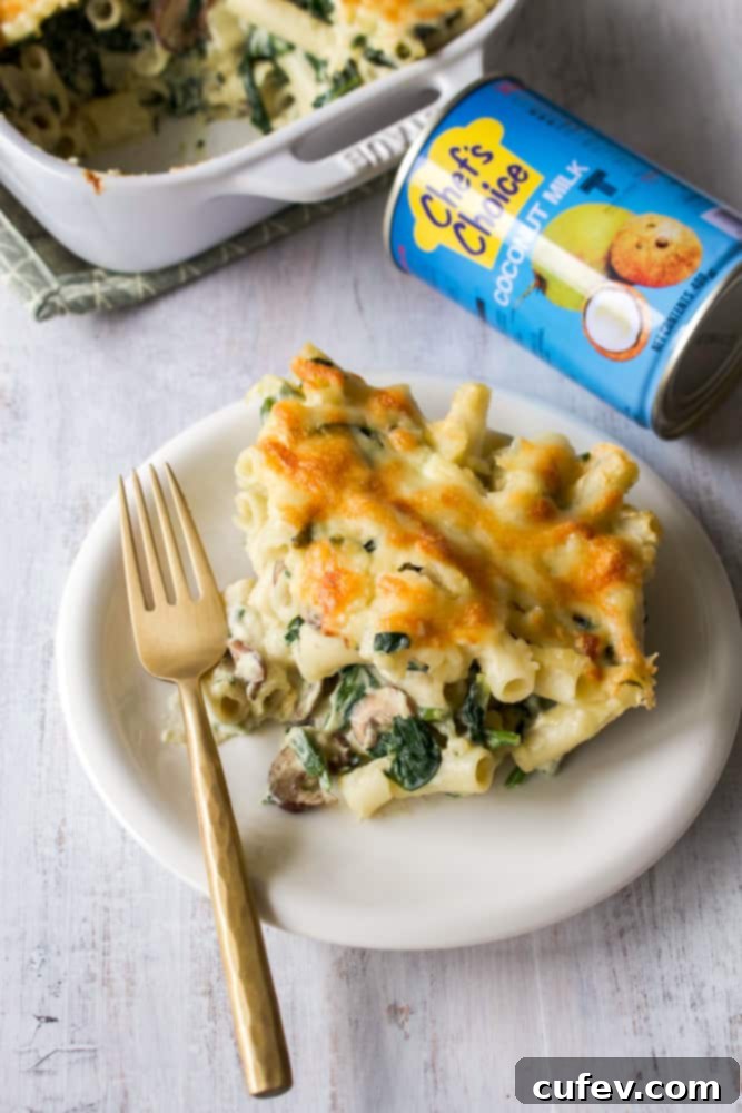 A close-up shot of a plate of macaroni gratin with a gold fork, ready to be eaten.