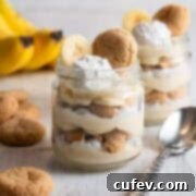 Luscious Vegan Banana Pudding 5 Two jars of vegan banana pudding with bananas in the background.