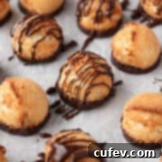 Plain and chocolate drizzled vegan coconut macaroons on a white surface, showcasing their golden texture and enticing appearance.