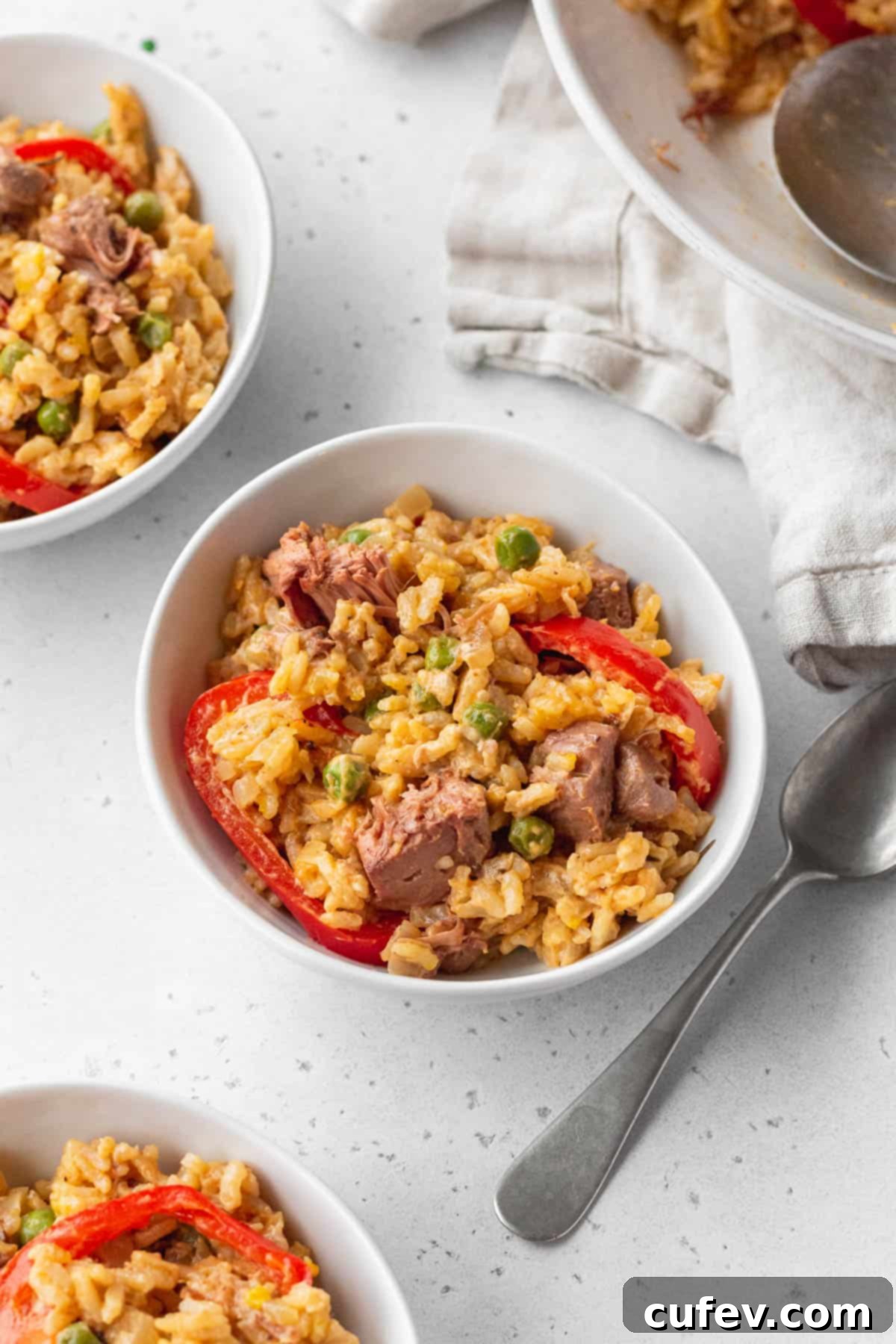 3 small bowls of Arroz a la Valenciana on a white surface.