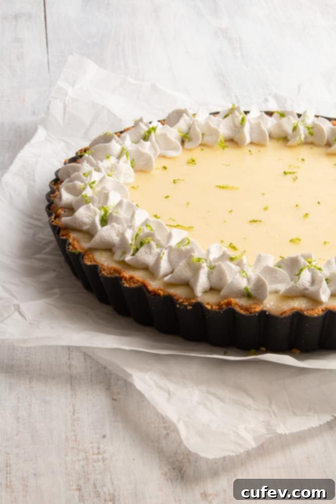Effortless Vegan Key Lime Bliss 4 A slice of creamy vegan key lime pie with a golden graham cracker crust, topped with coconut whipped cream and lime zest.