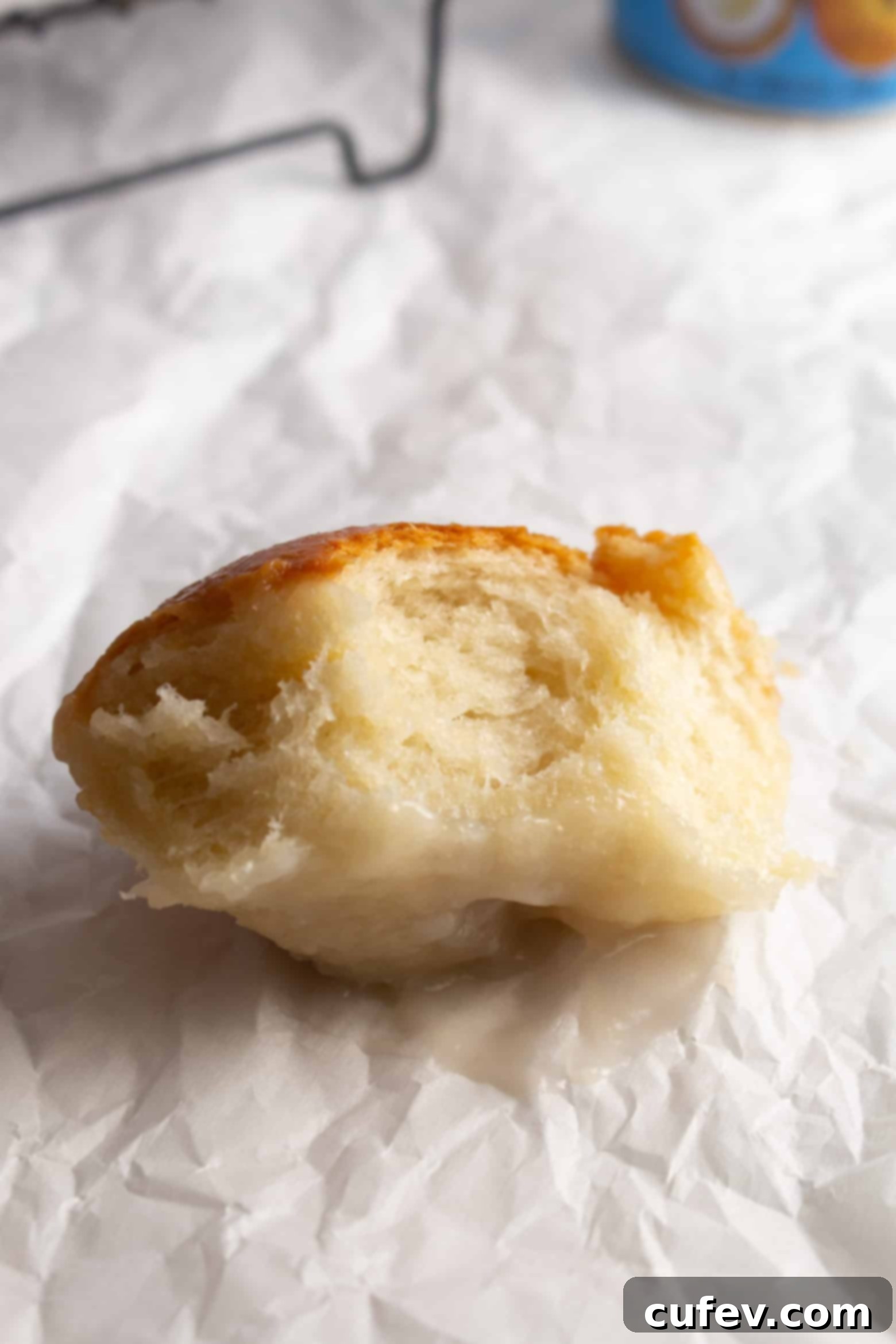 A sweet Samoan coconut roll, Pani Popo, bitten into to reveal its soft, fluffy interior and sticky glaze.