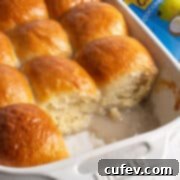 Pani popo (Samoan coconut buns) in a white baking dish, fresh from the oven and glazed.