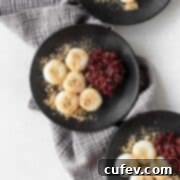 Shiratama on black plates next to some sweet red bean paste and kinako sprinkled on top.