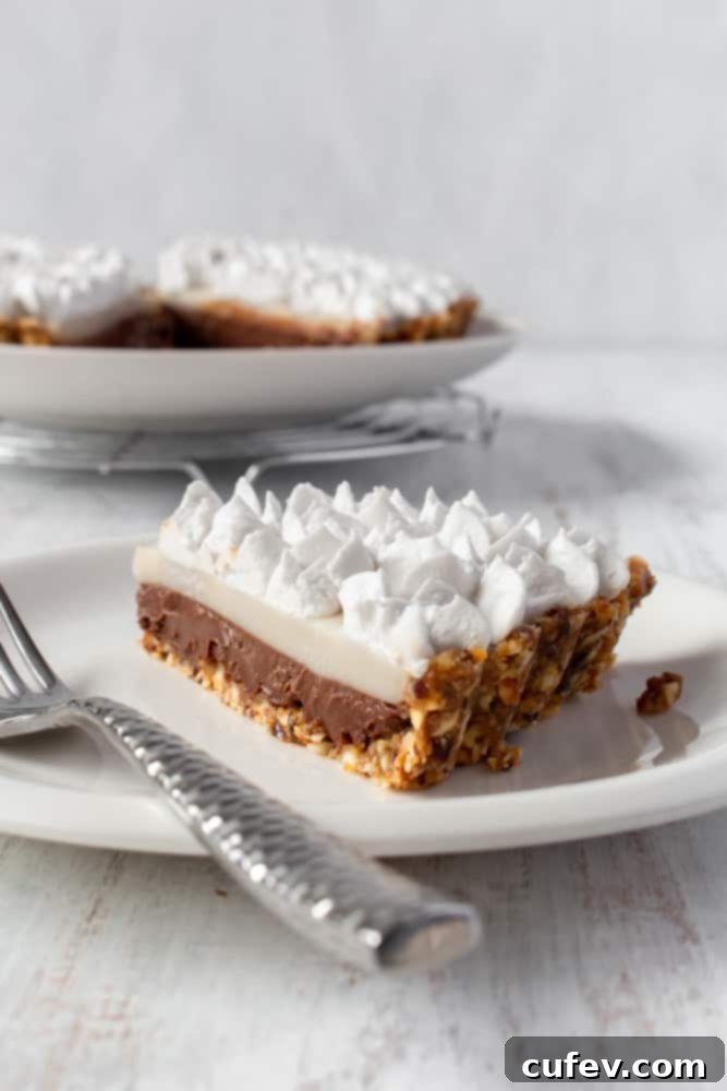 Hawaiian Chocolate Haupia Pie 2 A slice of chocolate haupia pie on a plate, showcasing its distinct layers of chocolate and white coconut.