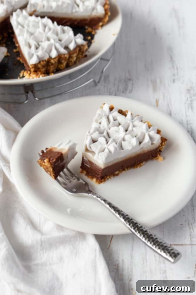 Hawaiian Chocolate Haupia Pie 3 A slice of vegan haupia pie on a plate with a fork holding a bite, showing the creamy texture and two distinct layers.