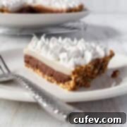 A slice of chocolate haupia pie on a white plate with a silver spoon.