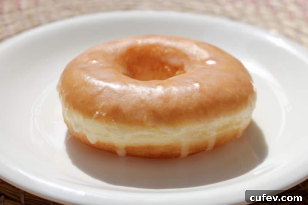 Freshly fried homemade doughnuts draining on a wire rack, showing off their perfect golden color and soft texture, ready for delicious toppings.