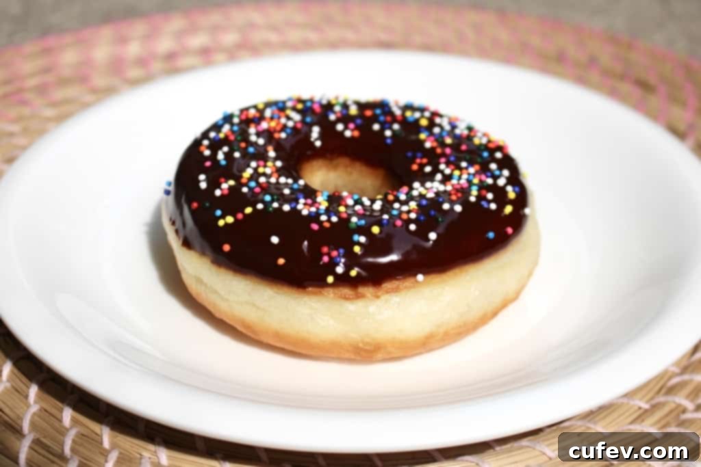 A close-up of a homemade yeasted doughnut, perfectly golden and fluffy, highlighting its irresistible texture. A true culinary achievement.