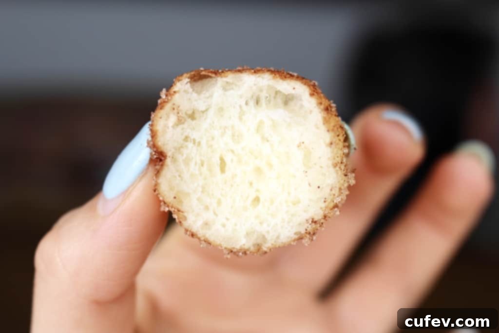 A close-up showing the cross-section of a super fluffy homemade doughnut, revealing its airy and tender crumb structure.