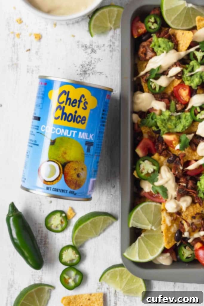 Smooth and creamy homemade vegan cashew queso poured into a serving bowl, ready for drizzling over nachos.