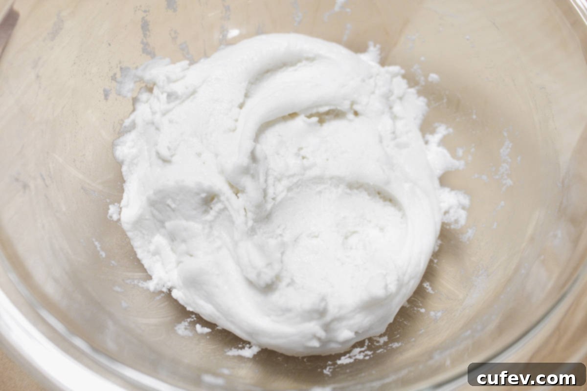 The smooth and pliable mochi dough after being thoroughly kneaded with water, showcasing its ready-to-steam consistency.