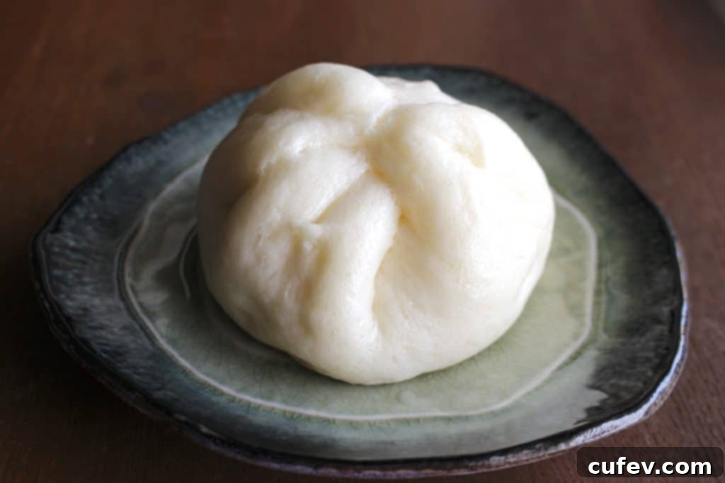 Freshly steamed pork buns cooling on a wire rack, a comforting savory treat for Mother's Day.