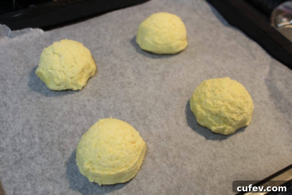 Freshly prepared corn cookie dough portions on a baking sheet, ready to be baked into cookies