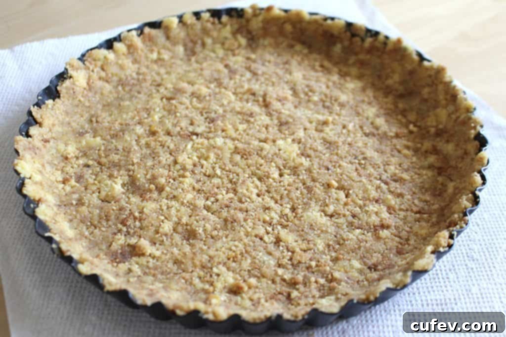 Crumbled corn cookies expertly pressed into a tart pan, forming a solid and even crust base