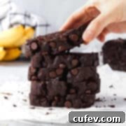 Chocolate Banana Bliss 5 A slice of chocolate banana bread being picked up by a hand, showcasing its delicious appearance.