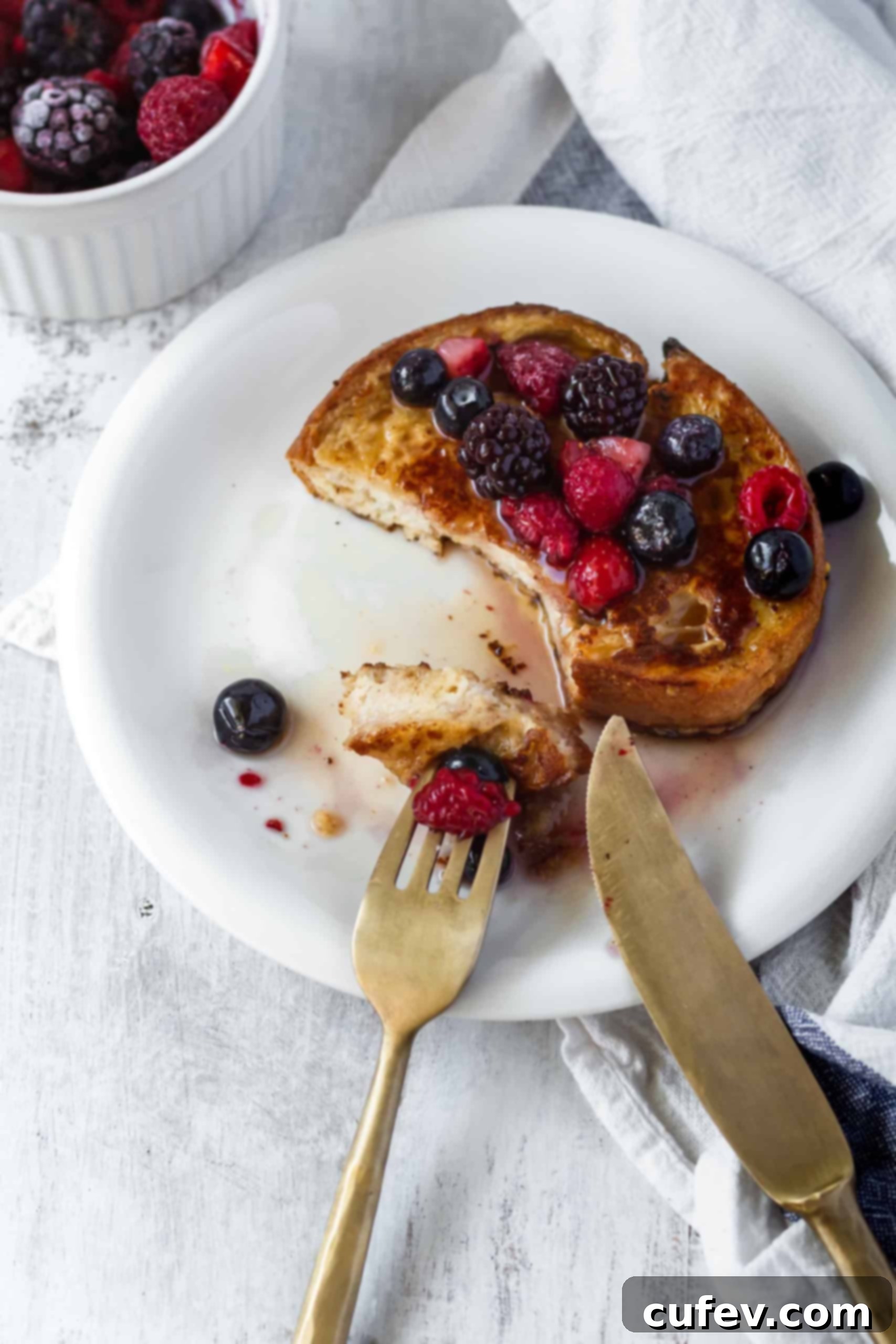 A close-up of a stack of golden-brown vegan French toast, invitingly plated for breakfast. #veganfrenchtoast #veganbreakfast #veganbrunch #plantbasedmeals #frenchtoast