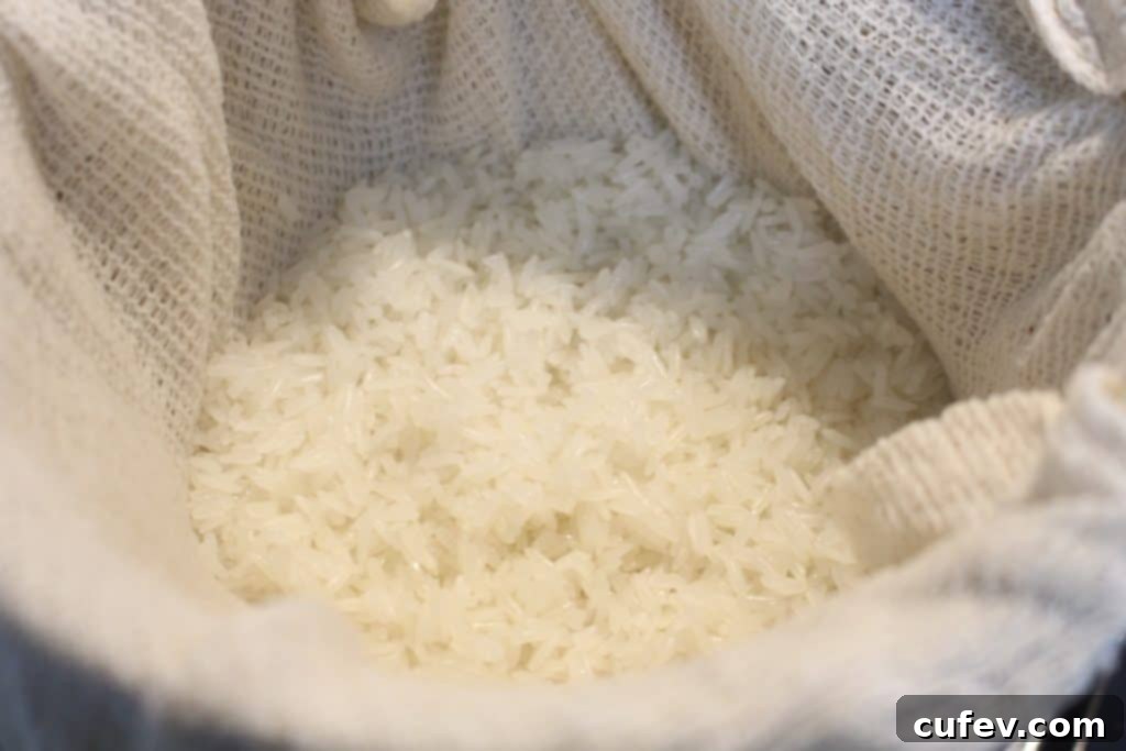 Steamed Thai sticky rice (Khao Niao) in a bowl, ready for coconut milk infusion