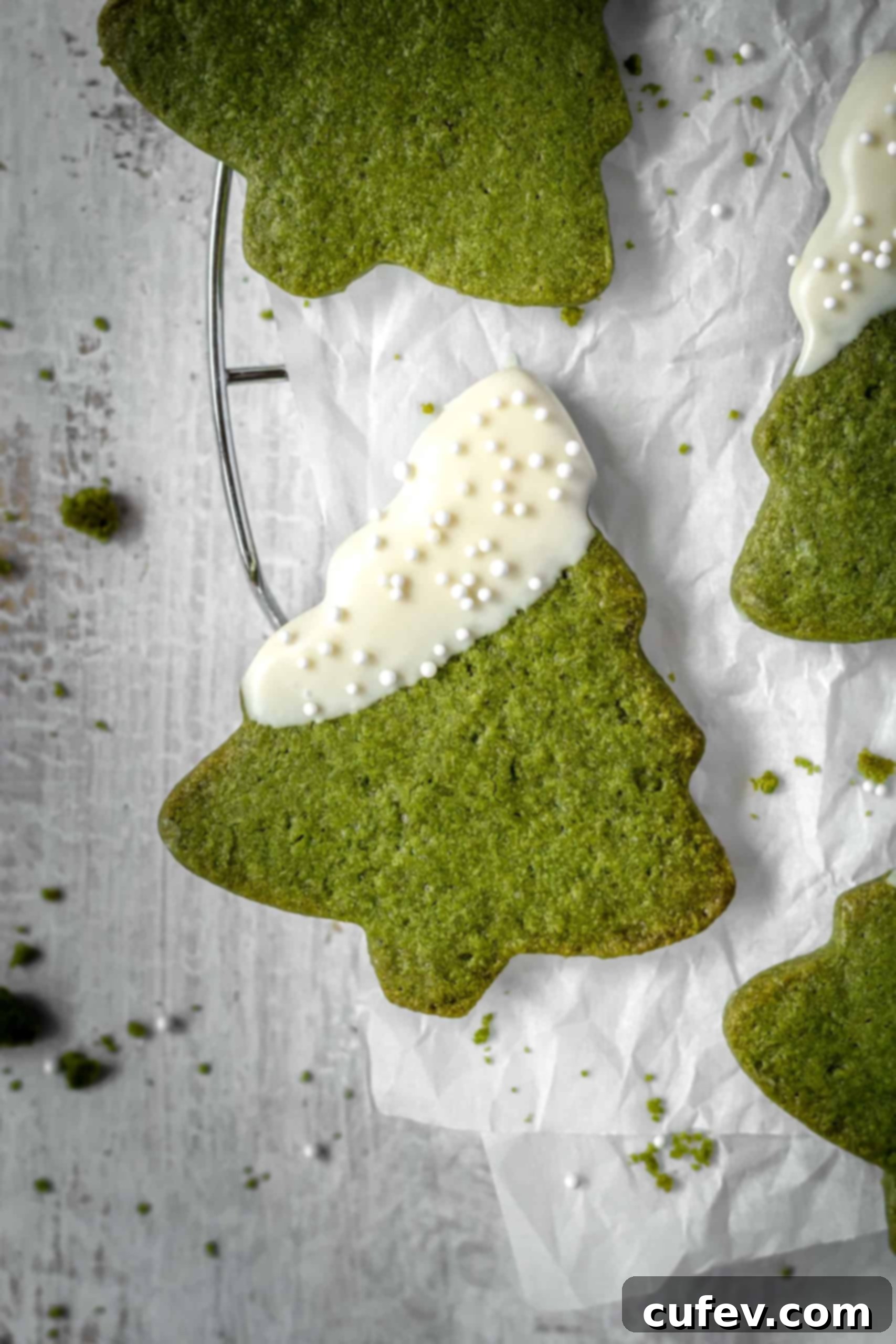Close-up of freshly baked matcha Christmas tree cookies on a cooling rack, ready for decoration.