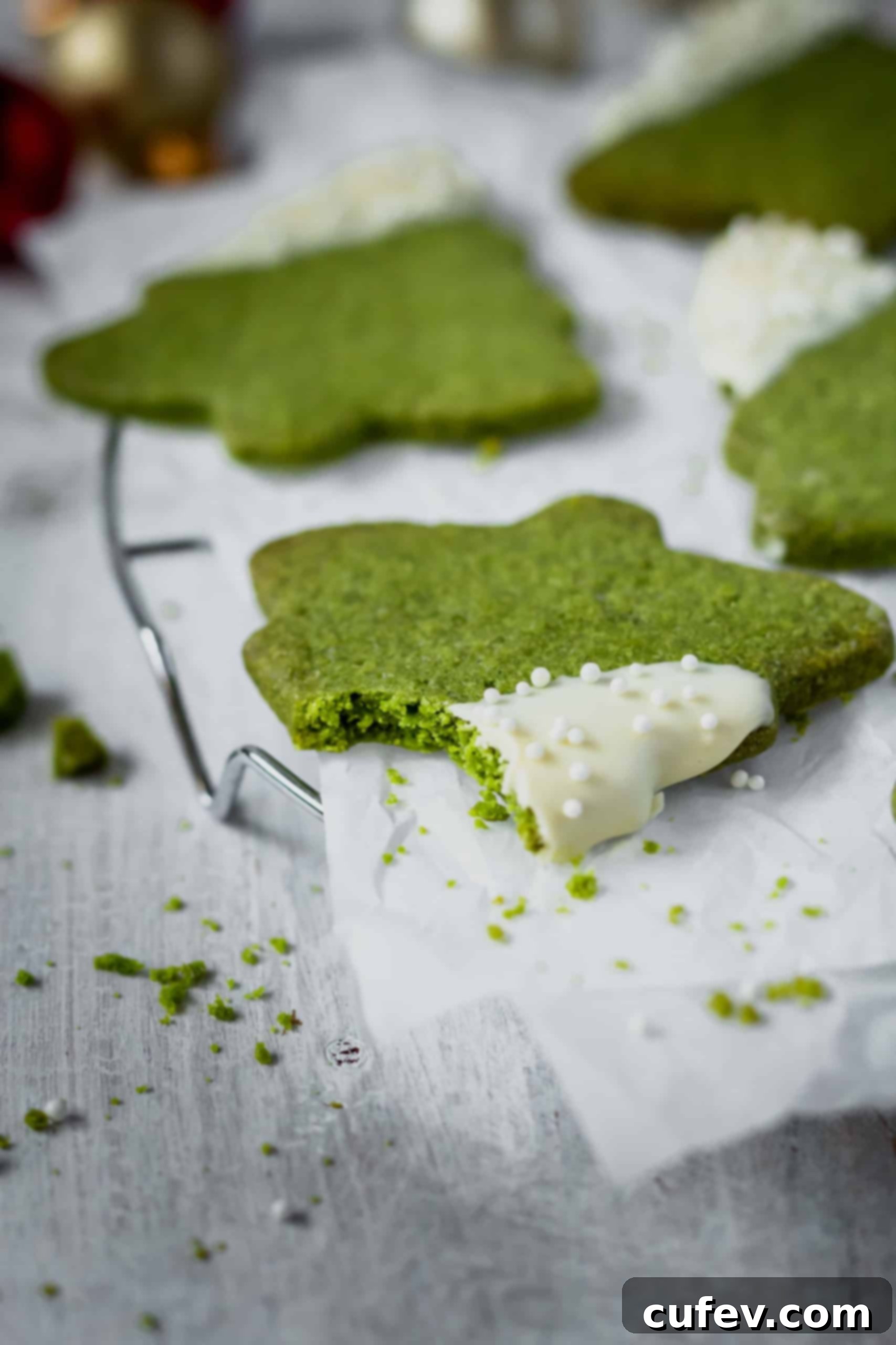 Freshly baked matcha Christmas tree cookies cooling on a wire rack before being decorated.