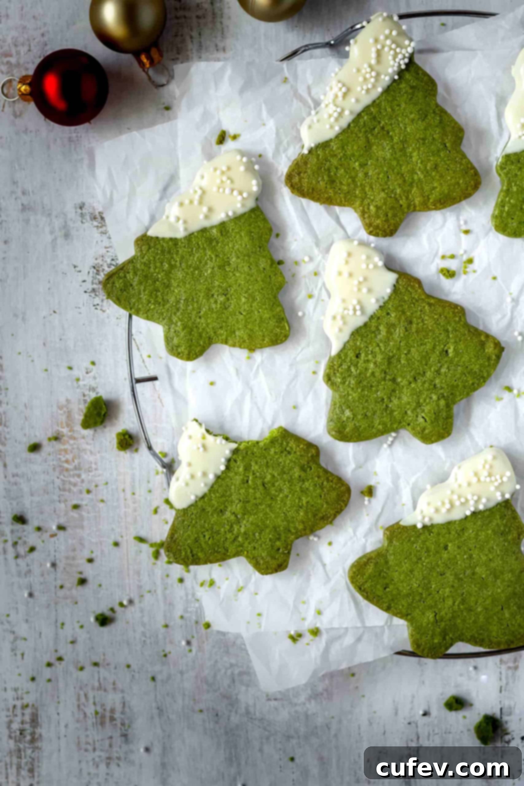 Beautifully decorated matcha Christmas tree cookies with white chocolate and sprinkles, ready for serving.