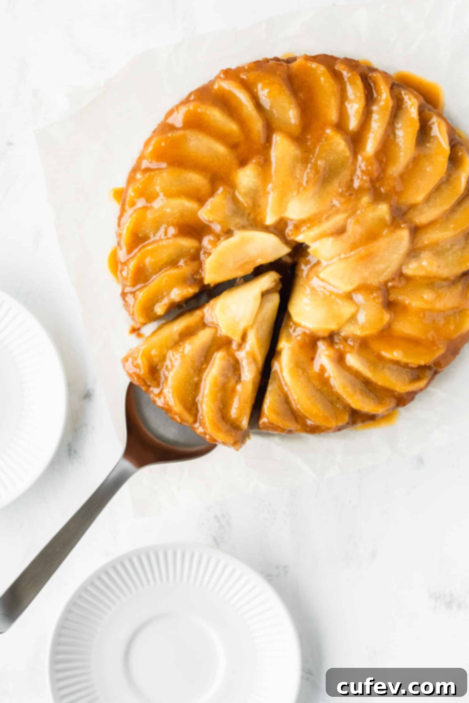 A stunning shot of a vegan apple upside-down cake with a single slice perfectly removed, showing the moist interior.