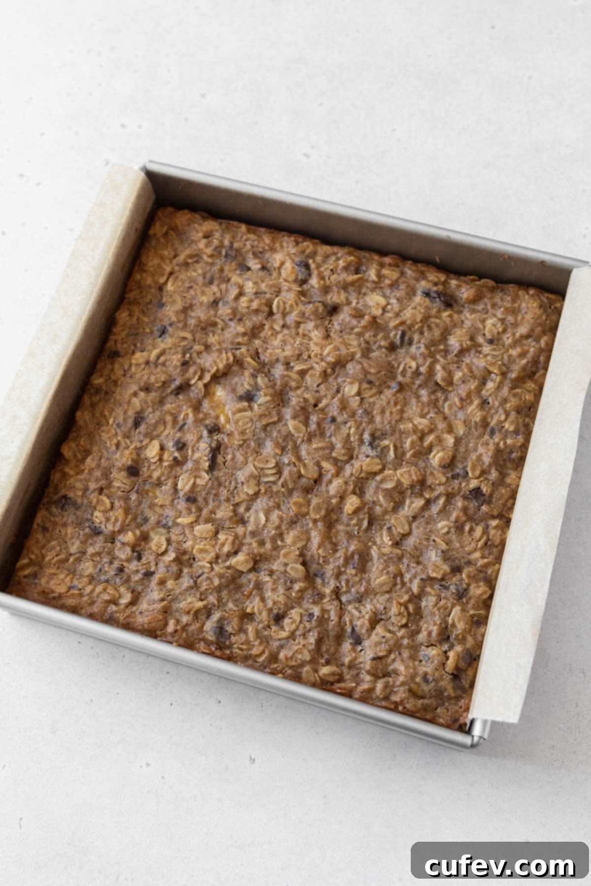 A baked pan of peanut butter banana oatmeal bars on the counter.