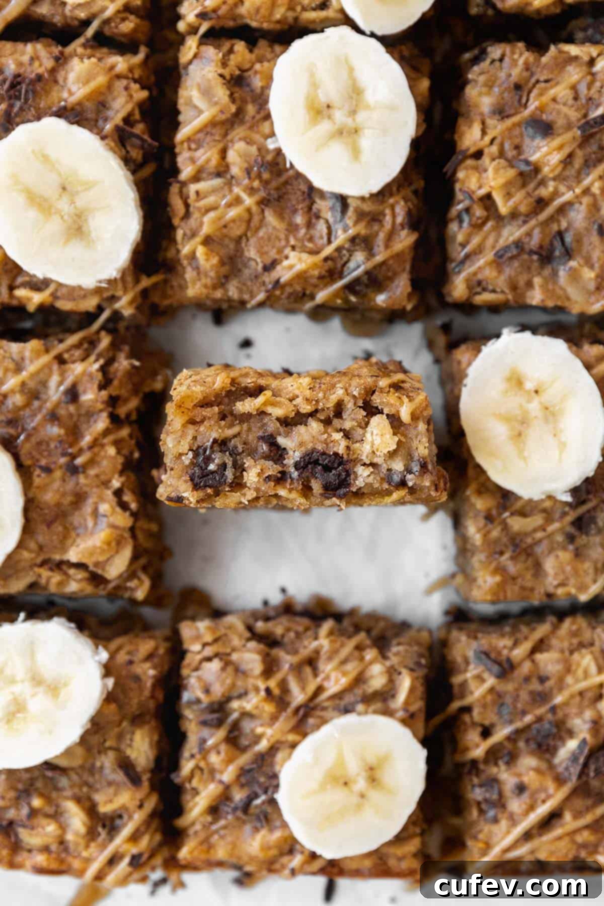 An overhead shot of peanut butter oatmeal bars on the counter with one bar in the center sitting on its side so you can see the inside.