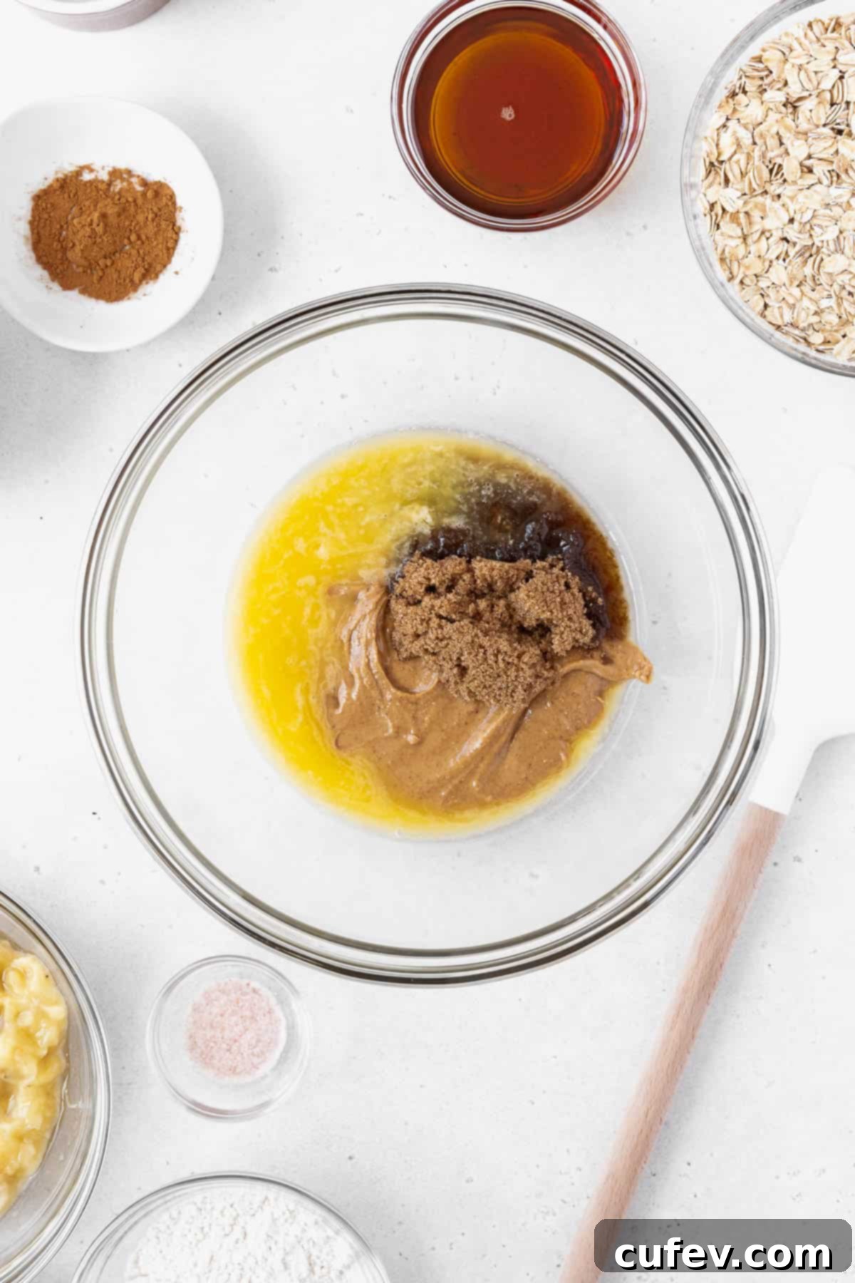 A mixing bowl with melted vegan butter, brown sugar, peanut butter, and maple syrup.