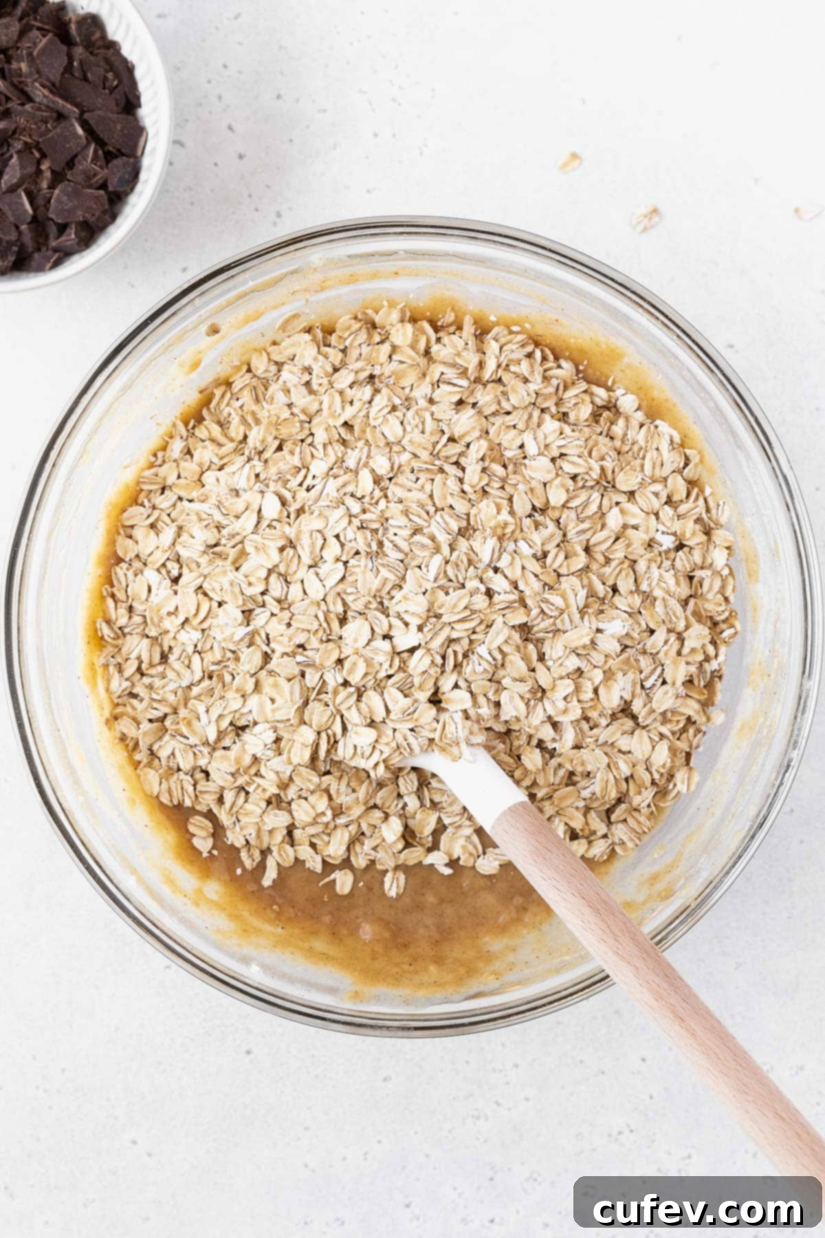 A mixing bowl of peanut butter banana bars with oatmeal on top.