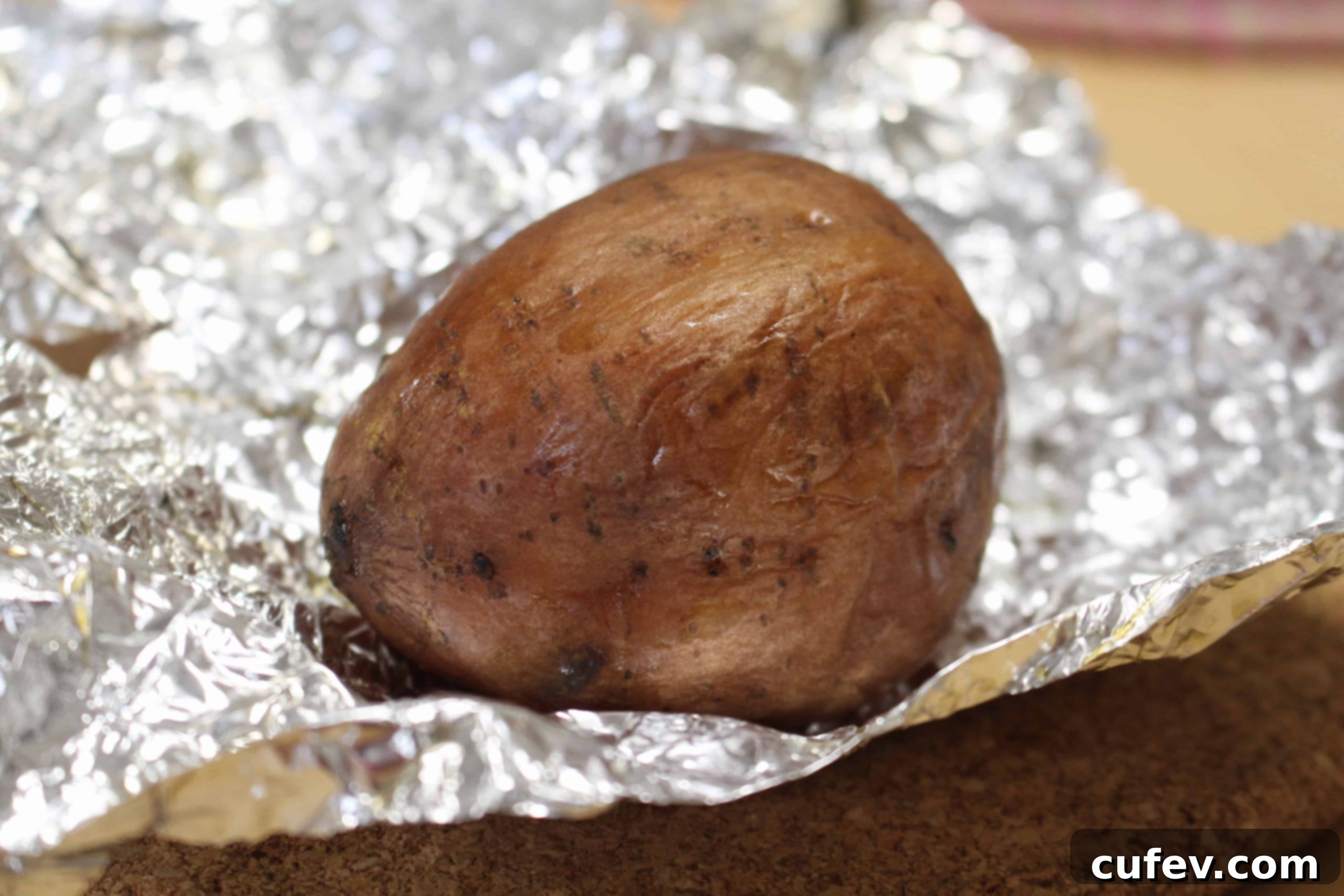 A perfectly baked Japanese sweet potato, fresh out of the oven, showing its tender and moist interior.