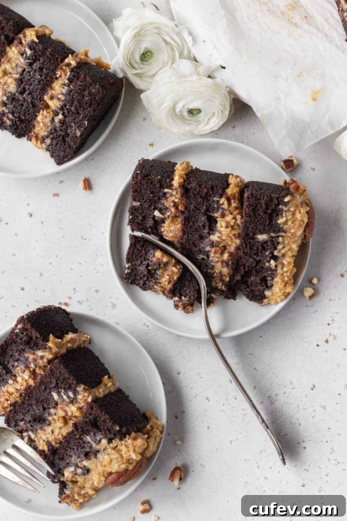 An overhead shot of three small white plates with a slice of gluten free German chocolate cake placed on each one.