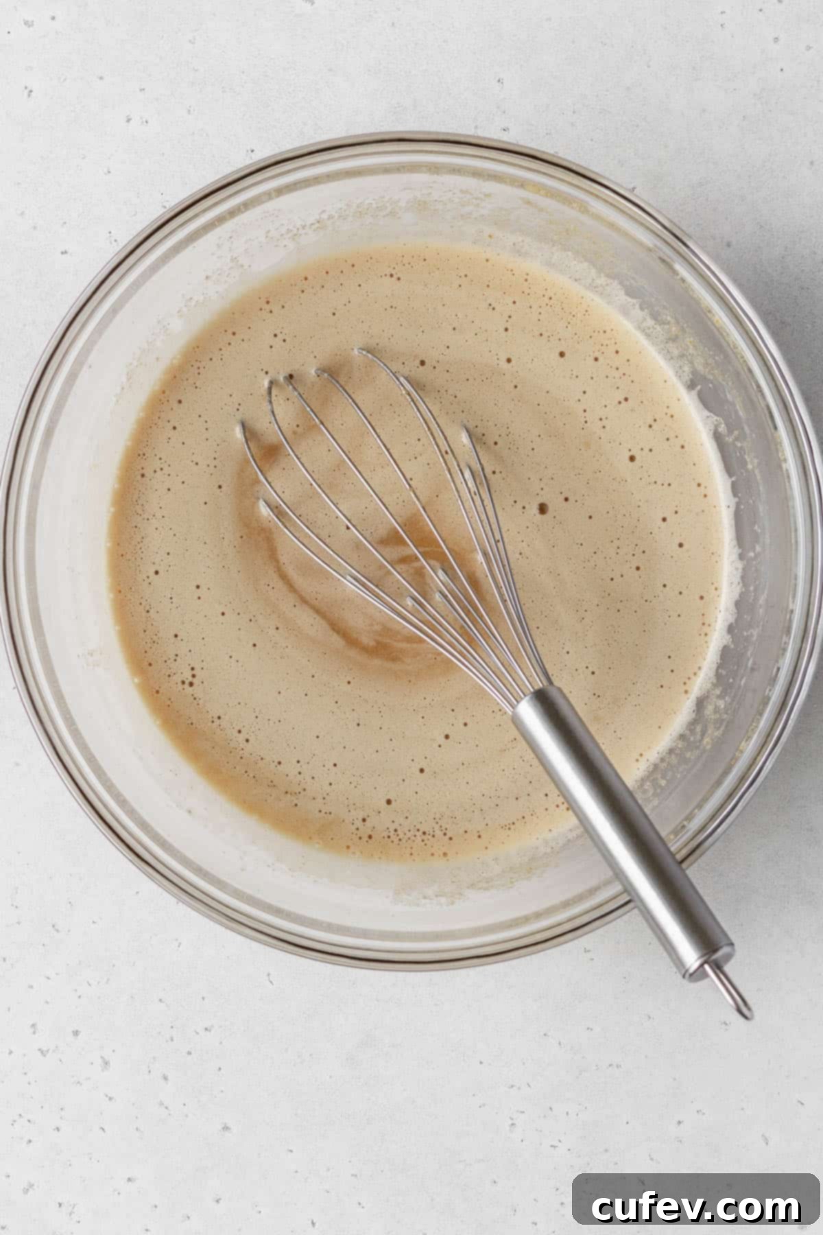 Wet ingredients whisked together in a large glass bowl.