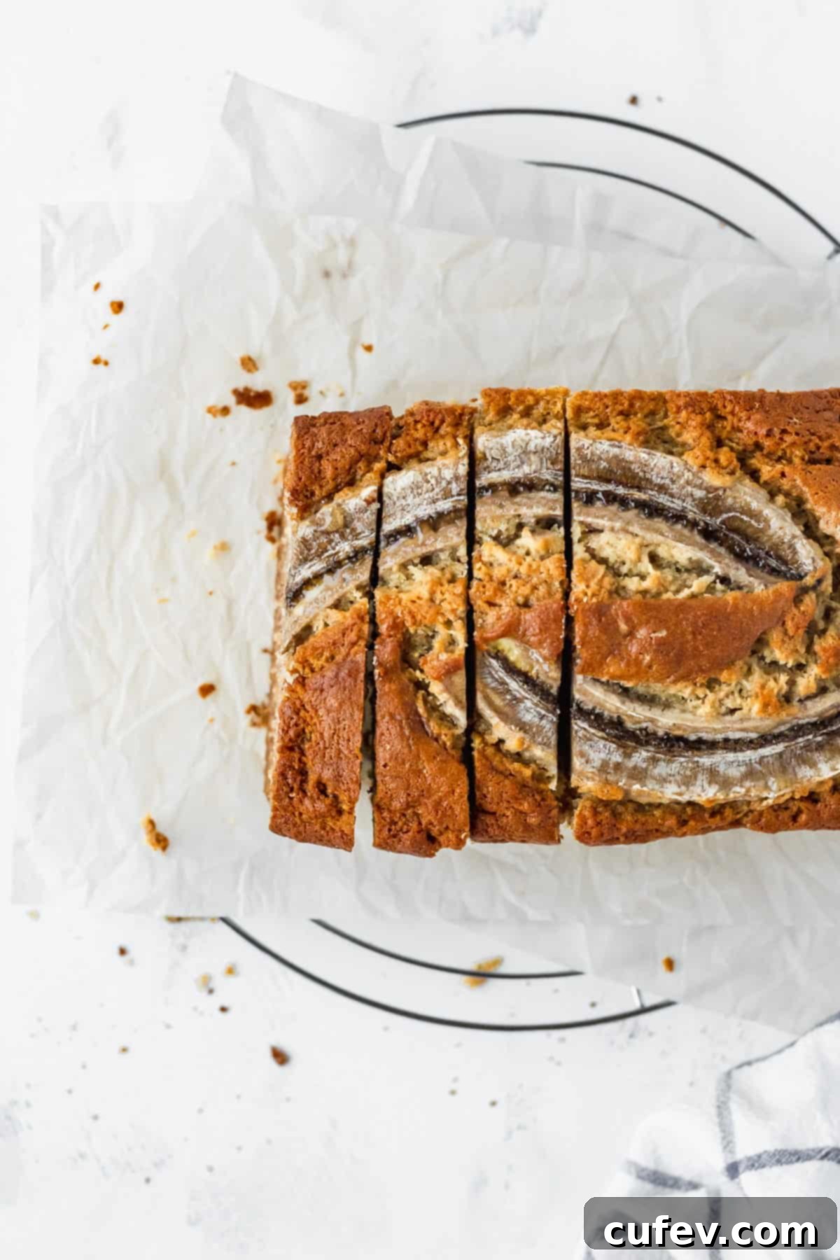 An inviting overhead shot of super moist banana bread, beautifully sliced to reveal its tender, banana-filled interior.