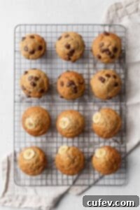 Twelve golden gluten-free banana muffins cooling on a wire rack after baking.