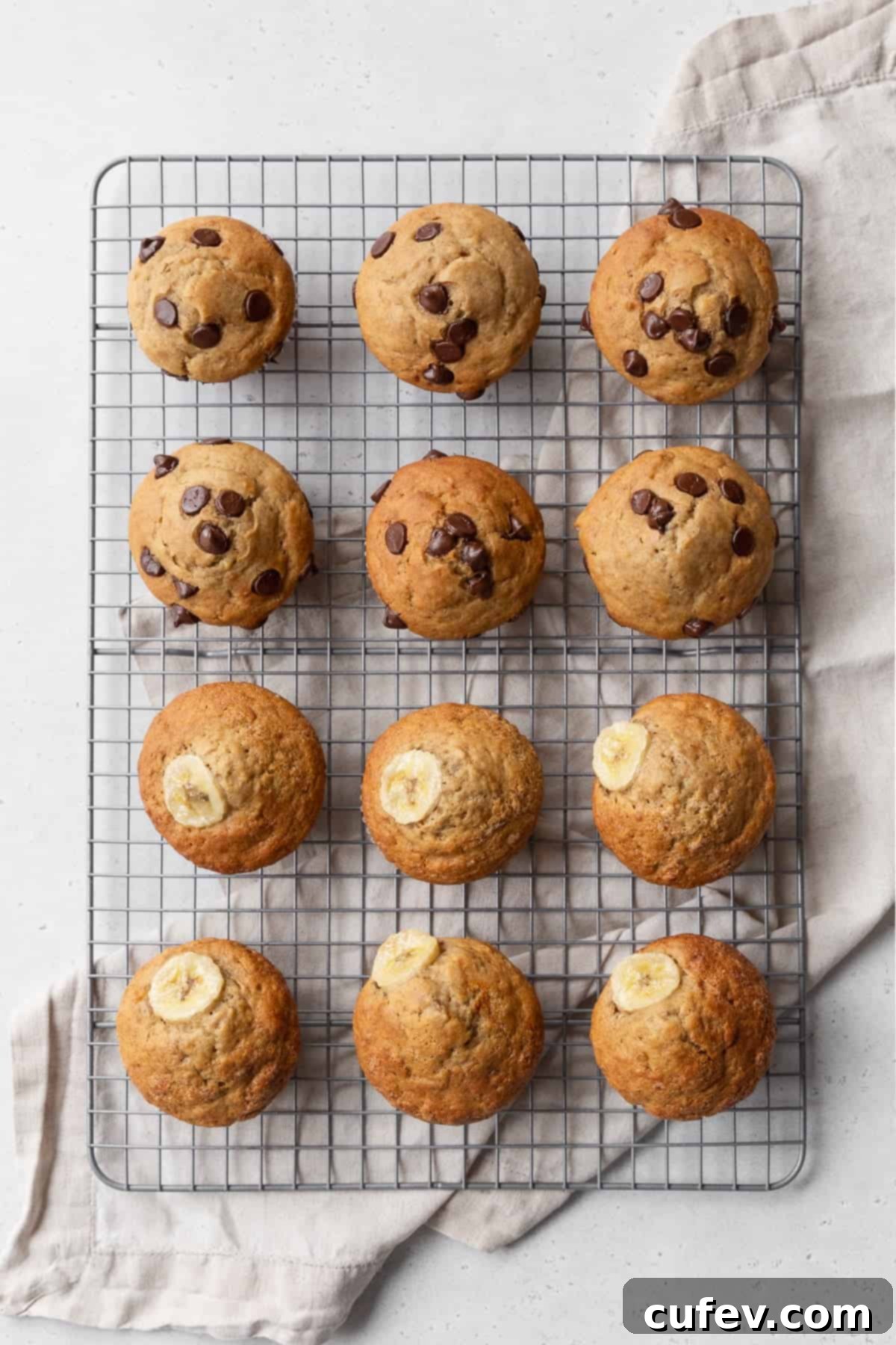 Twelve golden gluten-free banana muffins cooling on a wire rack after baking.
