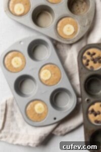 Gluten-free banana muffin batter perfectly portioned into a muffin pan, ready for baking.
