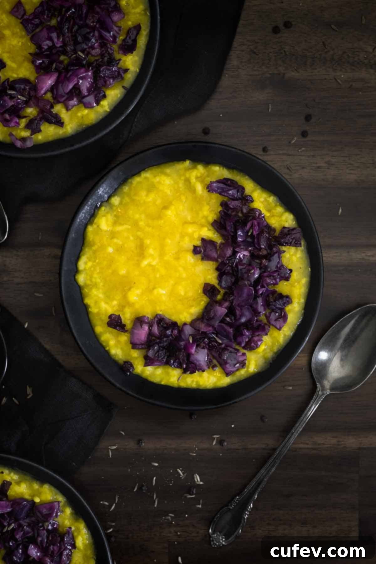 A close-up of a bowl of creamy Khichdi with sautéed red cabbage and onions, ready to be enjoyed.