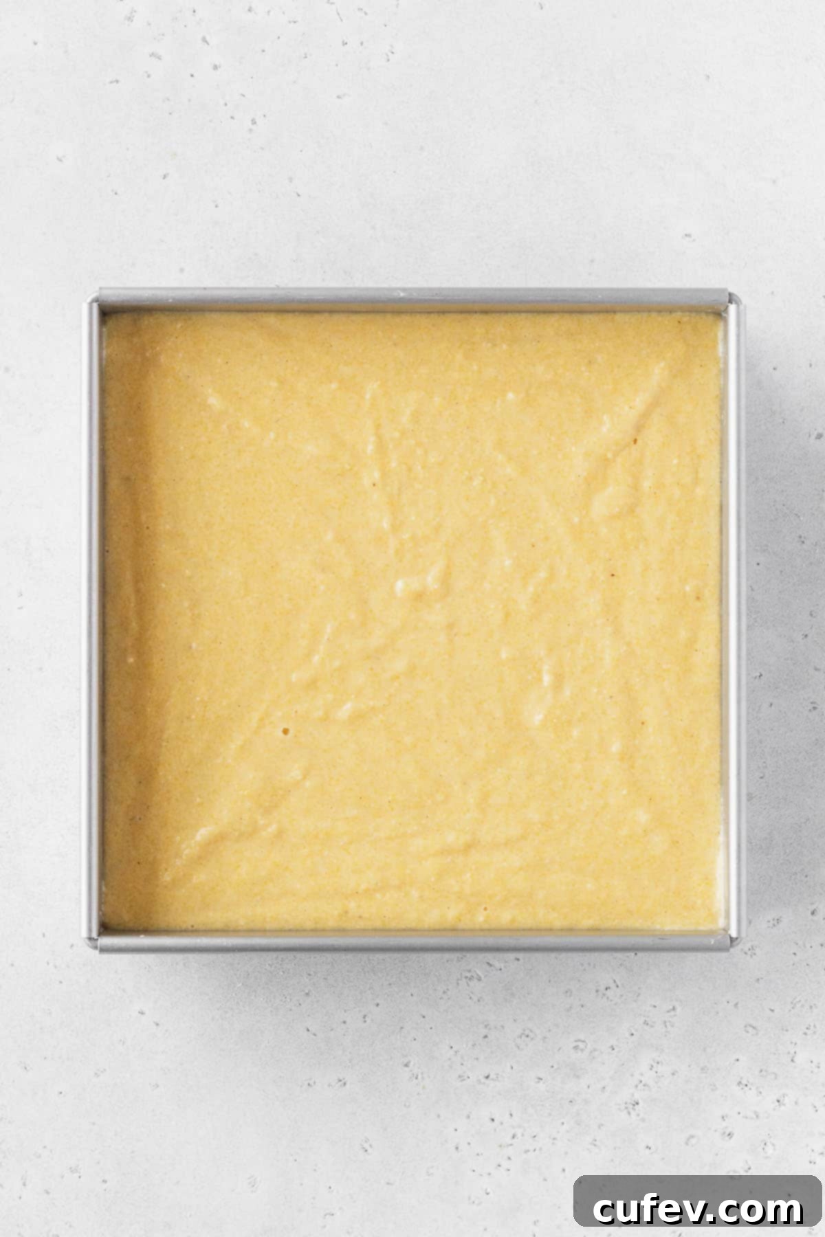 Golden Gluten-Free Cornbread Delight 11 Gluten-free dairy-free cornbread batter added to a prepared baking tin, ready for the oven.