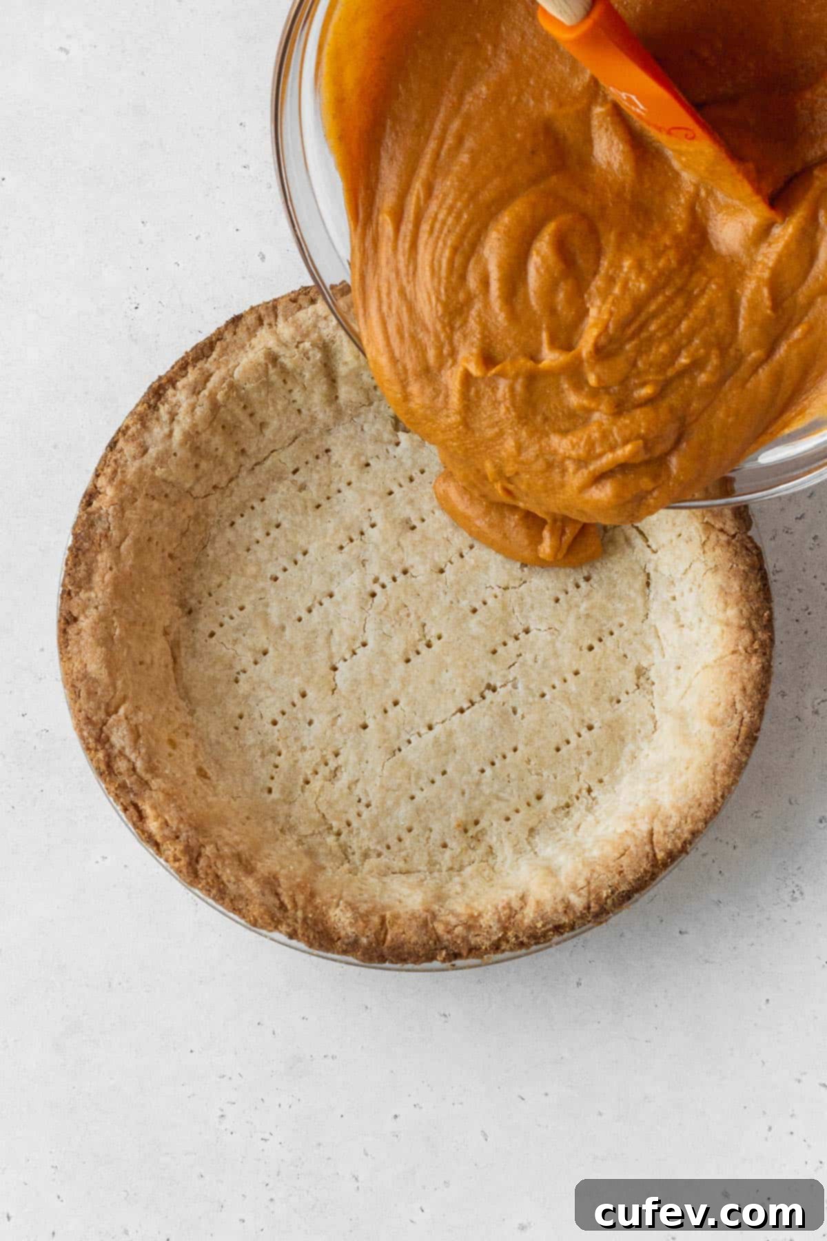Dairy-free pumpkin pie filling smoothly poured into the perfectly baked pie crust, ready for its final transformation in the oven.