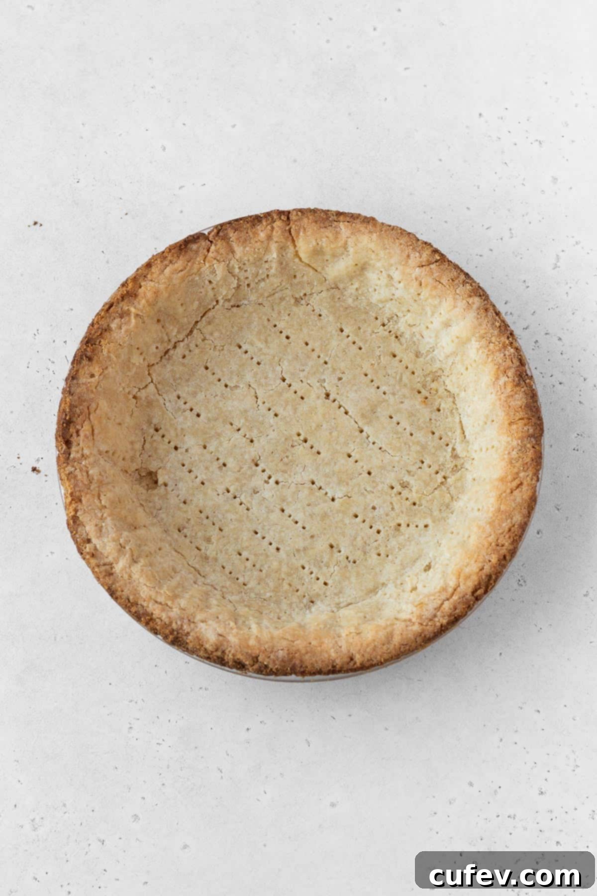 A golden-brown blind-baked pie shell, perfectly shaped and ready to receive the delicious pumpkin filling, highlighting a crucial step for a non-soggy crust.