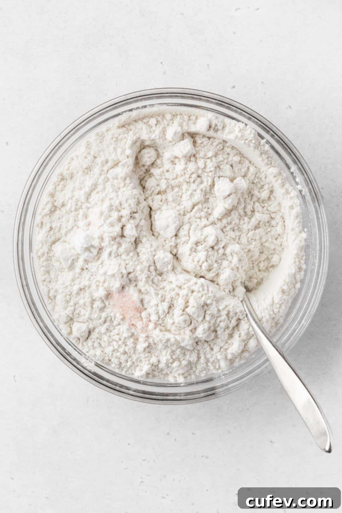 Dry ingredients for gluten-free dairy-free chocolate chip cookies, including flour, salt, baking soda, and baking powder, whisked together in a bowl.