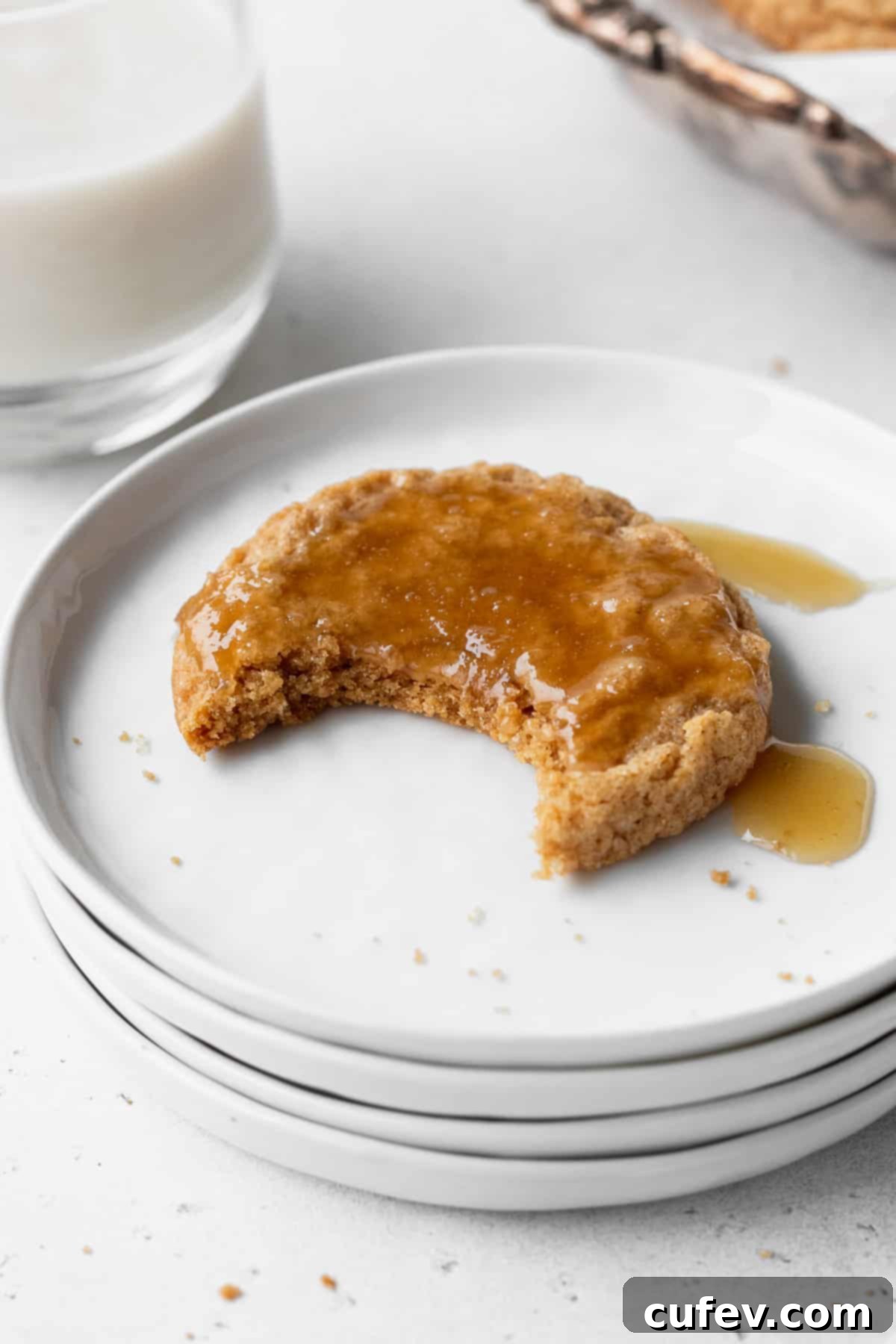 Perfectly Chewy Gluten-Free Ginger Cookies 6 A bitten ginger cookie with a bite taken out on a white plate.