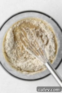 Dry ingredients being whisked into wet ingredients.