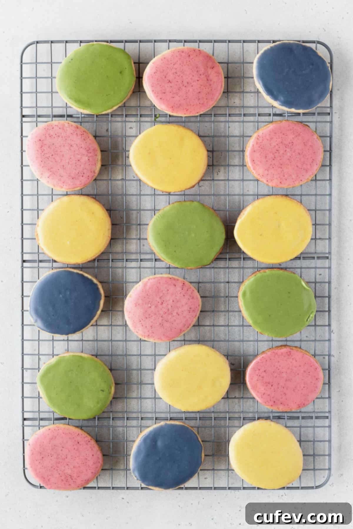 Blue, green, yellow, and pink vegan cookie icing in small bowls.