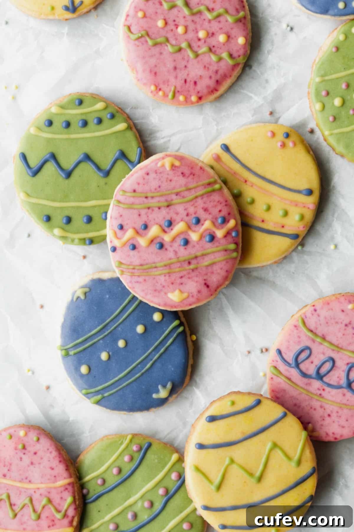 Overhead shot of decorated Easter cookies on a white surface.