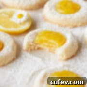 A bitten lemon curd cookie on a piece of parchment paper.