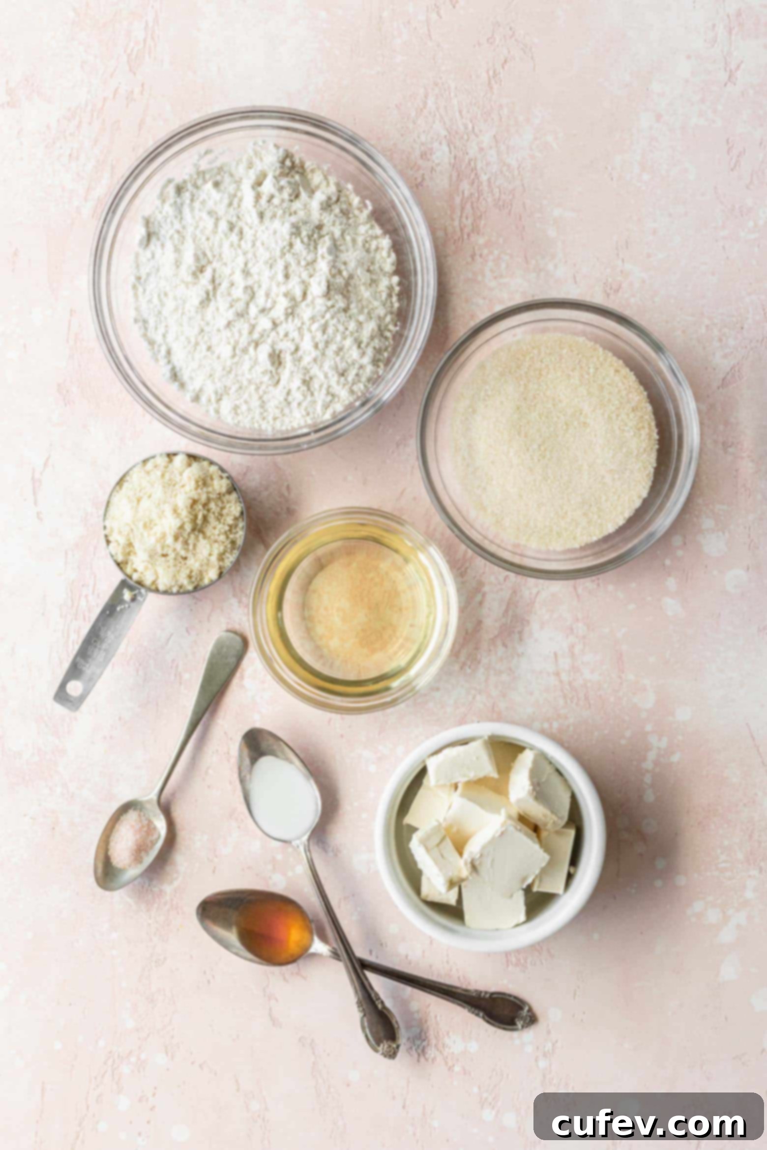 Various vegan sugar cookie ingredients measured out into bowls, meticulously arranged on a charming pink surface, ready for baking.