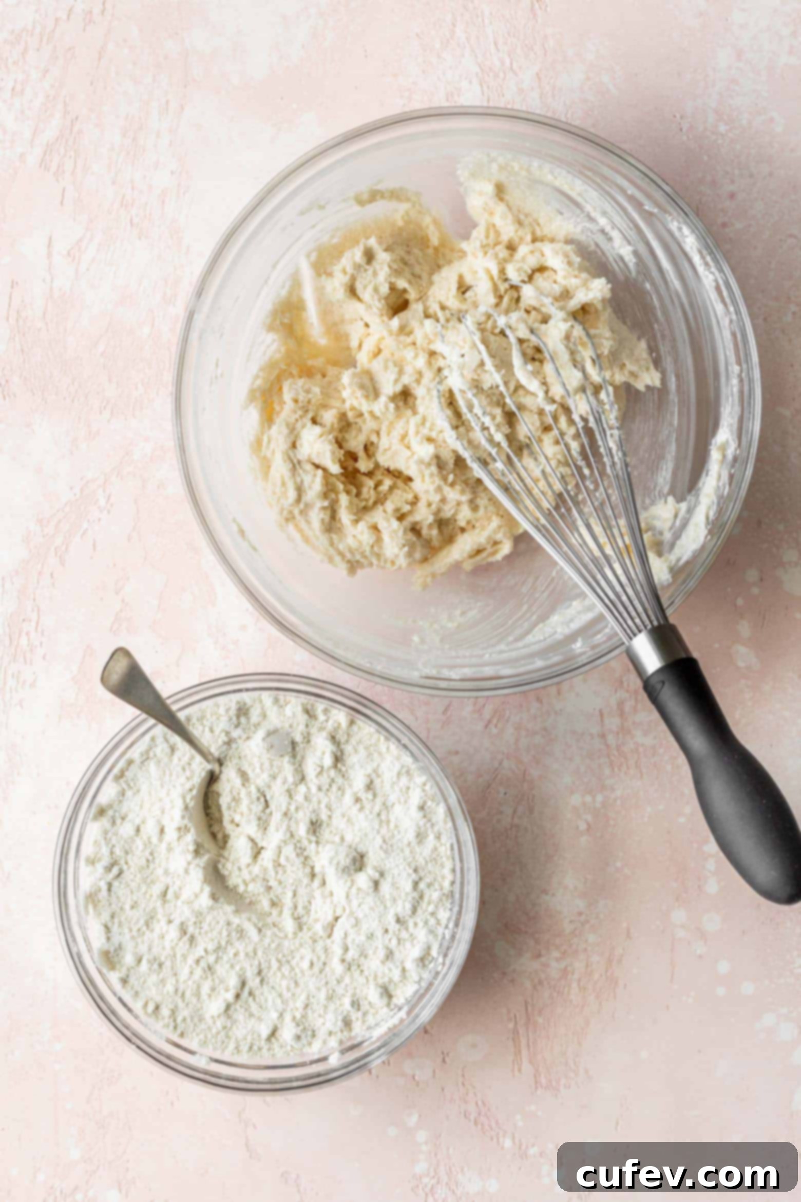 Adding the precisely measured dry ingredients into the creamy mixture of butter and sugar.
