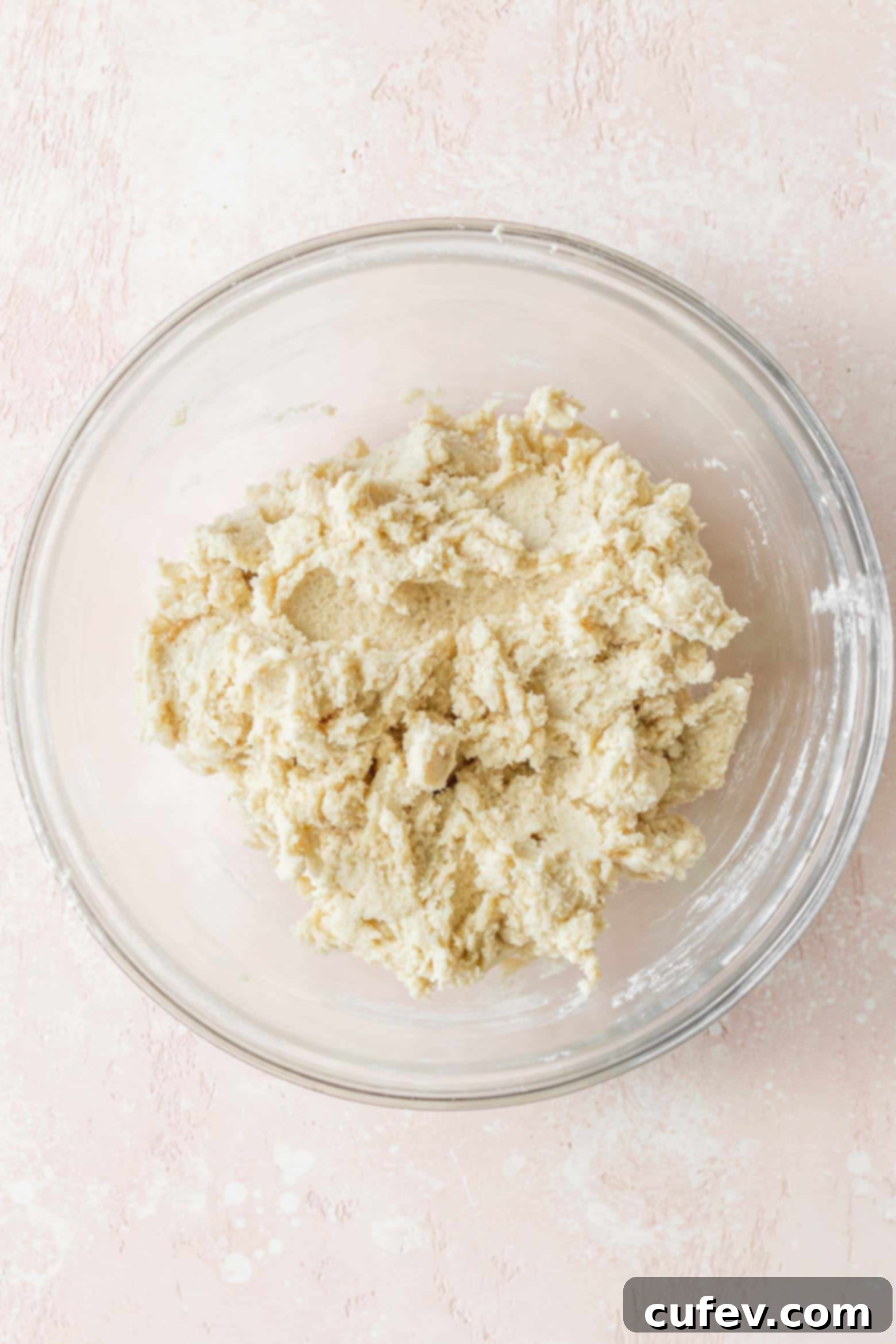 Smooth and ready-to-chill vegan sugar cookie dough resting in a clear glass bowl.